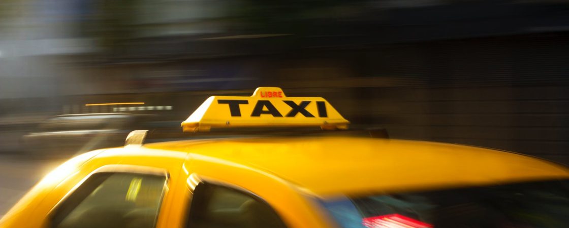panning photography of yellow taxi