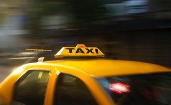 panning photography of yellow taxi