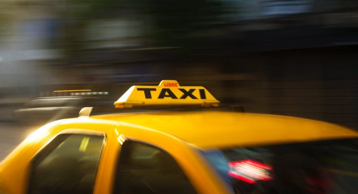 panning photography of yellow taxi