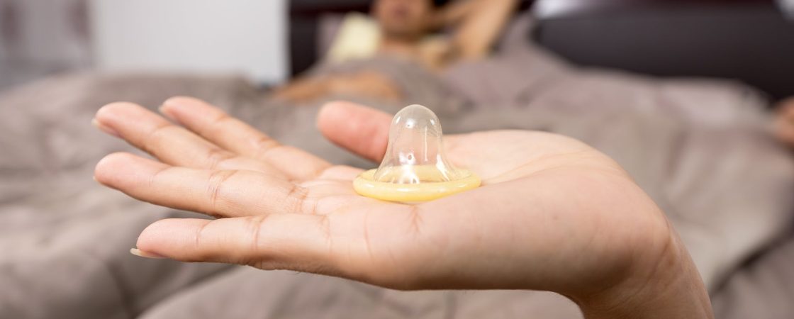close up of woman holding condom