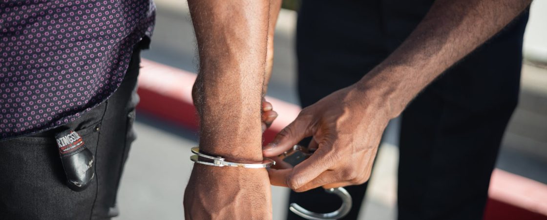 police officer putting handcuffs on another person