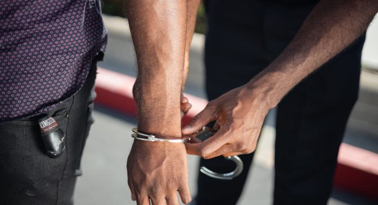 police officer putting handcuffs on another person