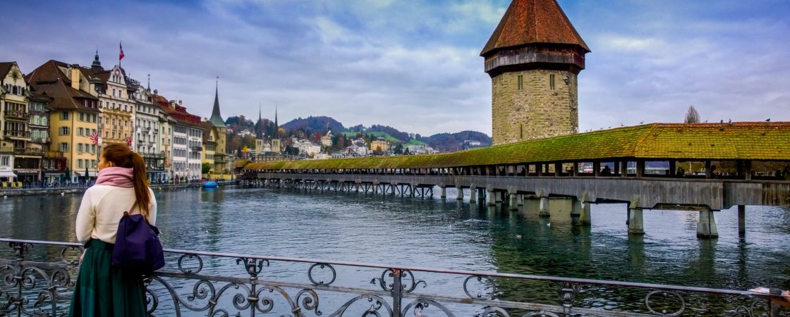 woman standing against handrails beside body of water