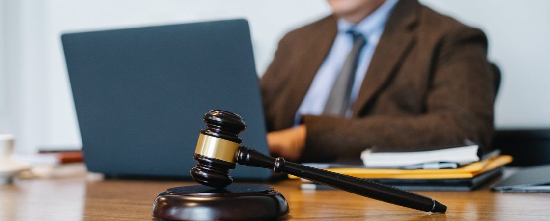 crop asian judge working on laptop in office