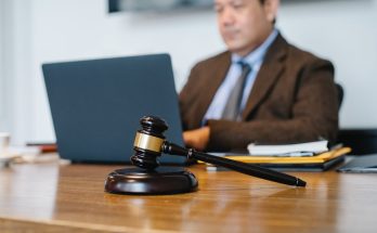 crop asian judge working on laptop in office