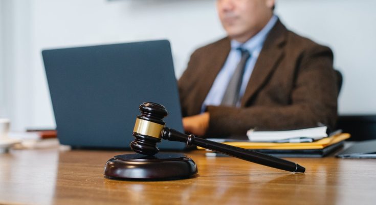 crop asian judge working on laptop in office